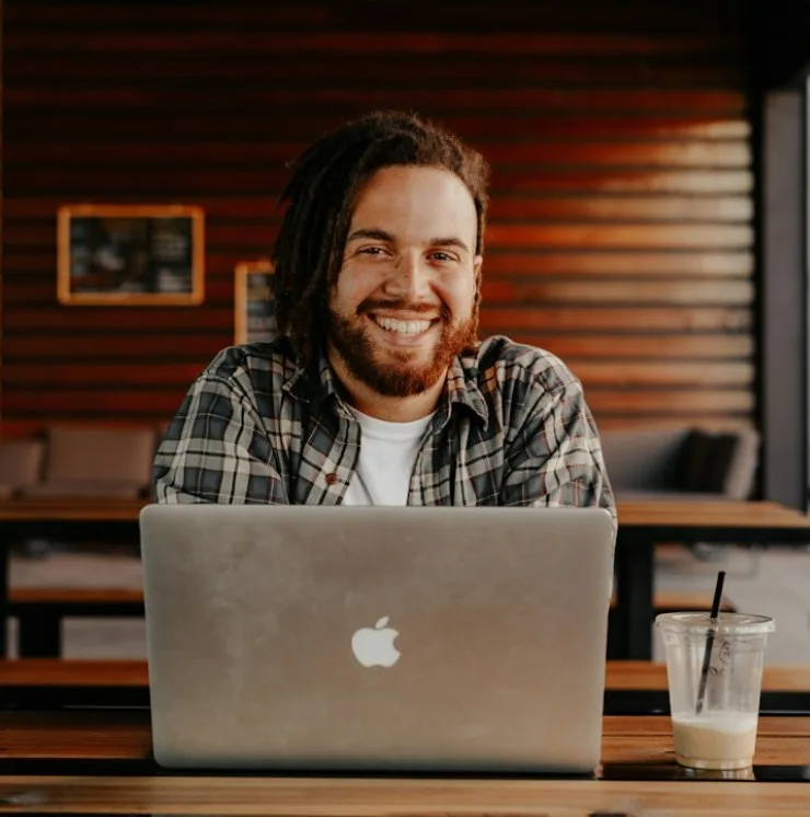 Restaurateur souriant devant son ordinateur portable